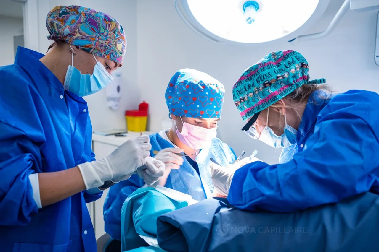 Trois membres de l’équipe réunis autour du patient pendant l’intervention.